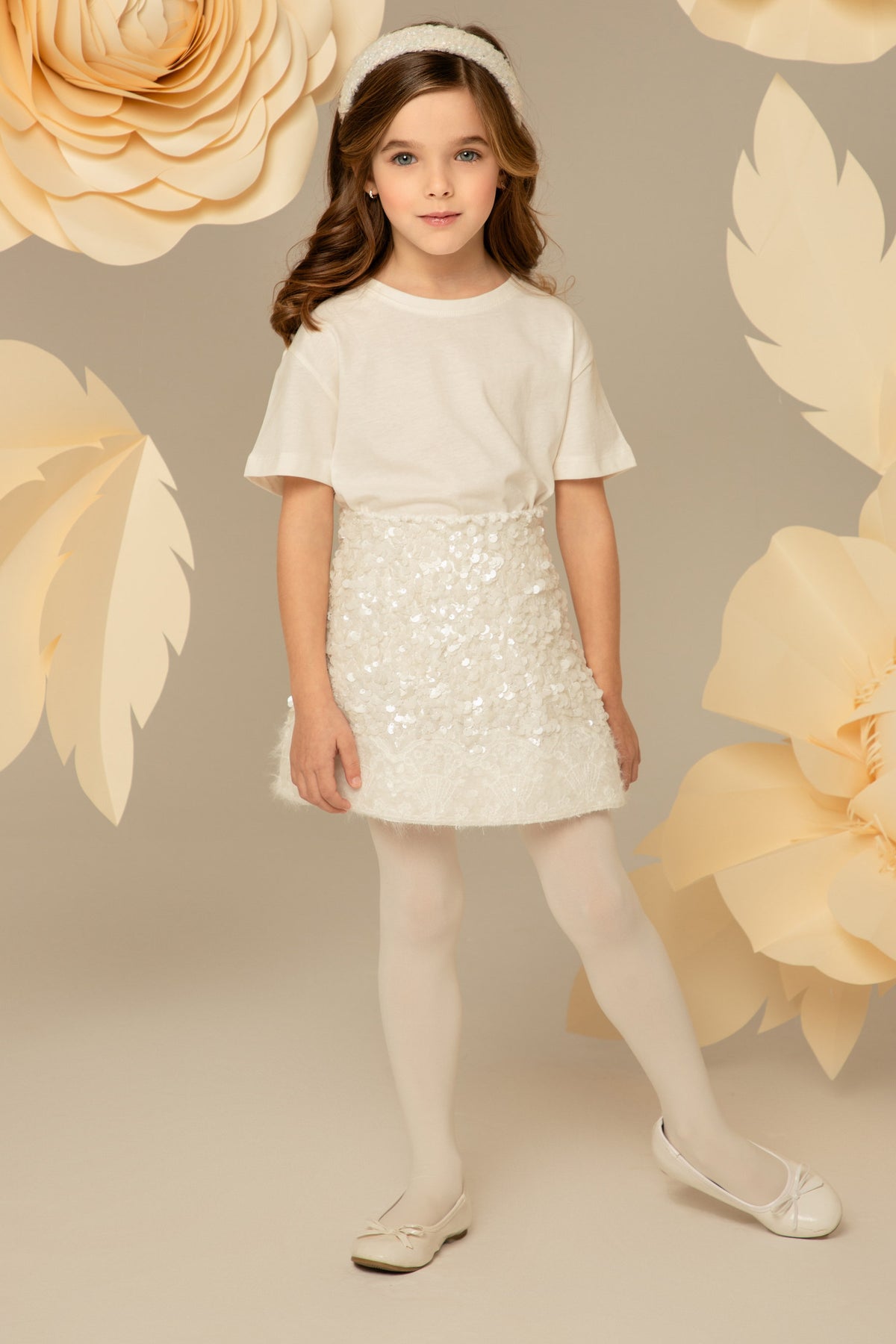 Бялата пола с пайети, съчетана с едноцветен топ